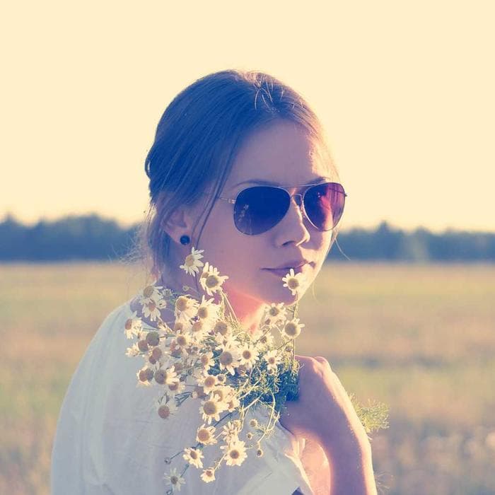 Woman holding wildflowers in golden light
